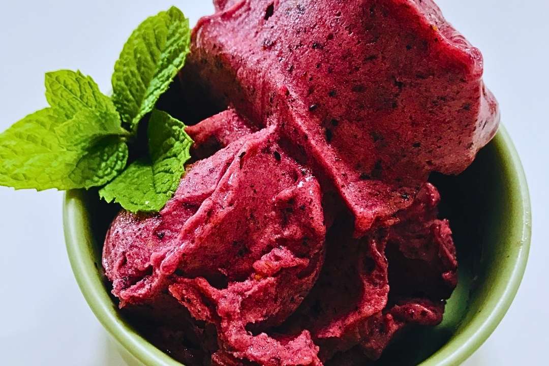 bowl of blueberry sorbet with sprig of mint