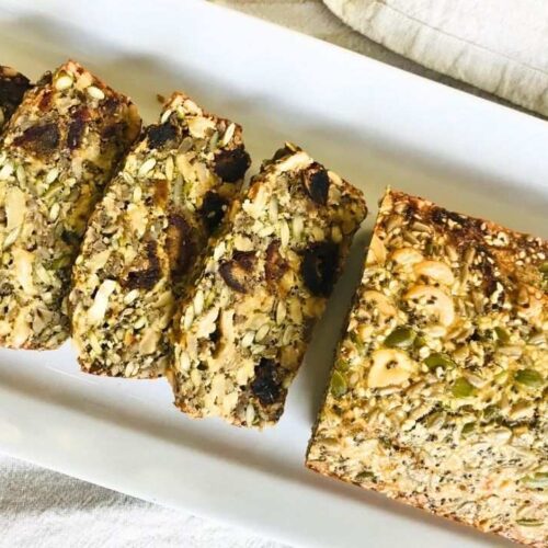 flat lay of half a loave of seed bread recipe that half is cut into 4 slices
