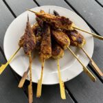 cooked satay chicken sticks on a plate