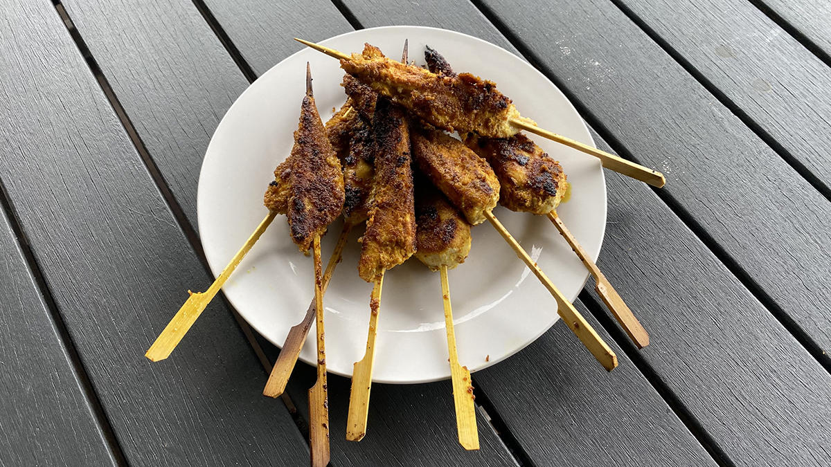 cooked satay chicken sticks on a plate