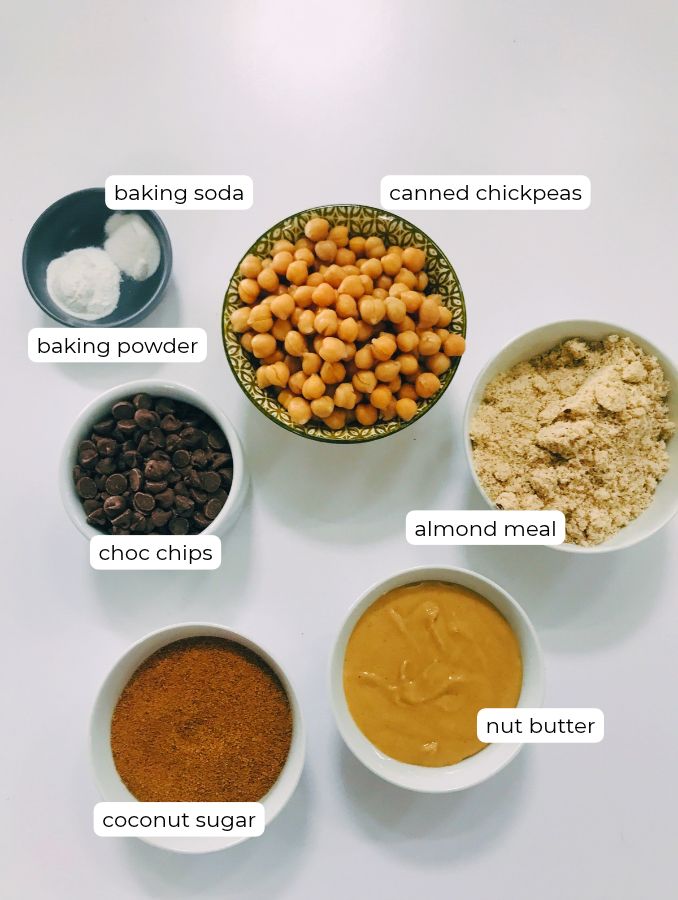 ingredients for chocolate chip chickpeas cookies in bowls on a white background 