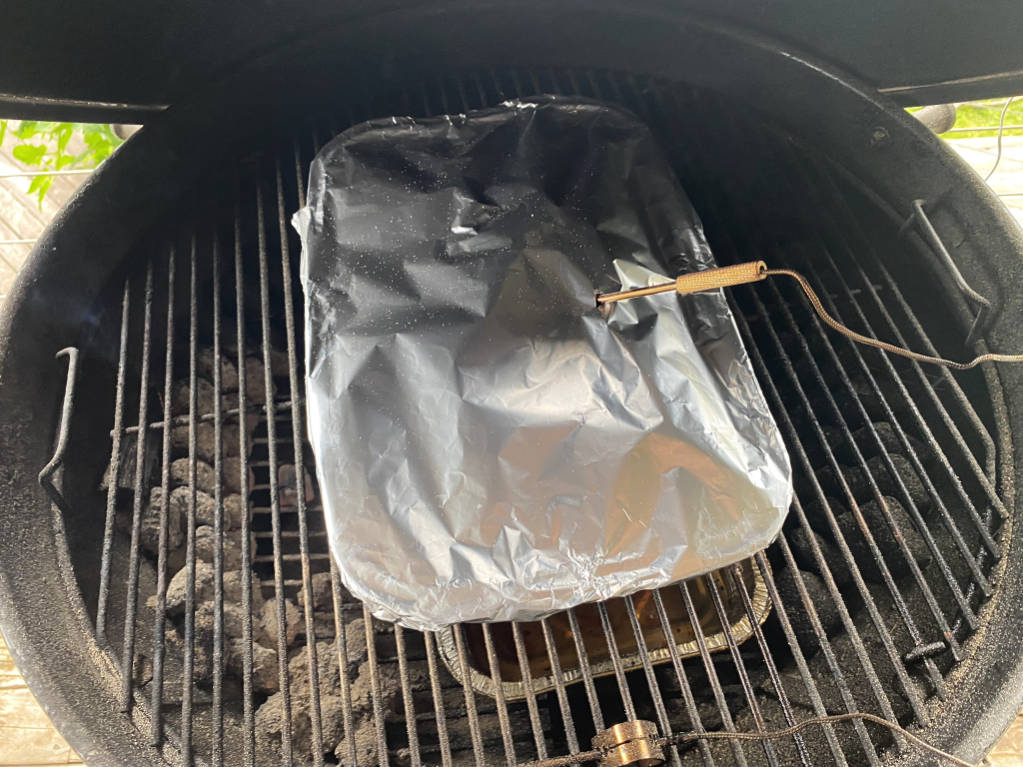 returning the foil covered pork to the weber